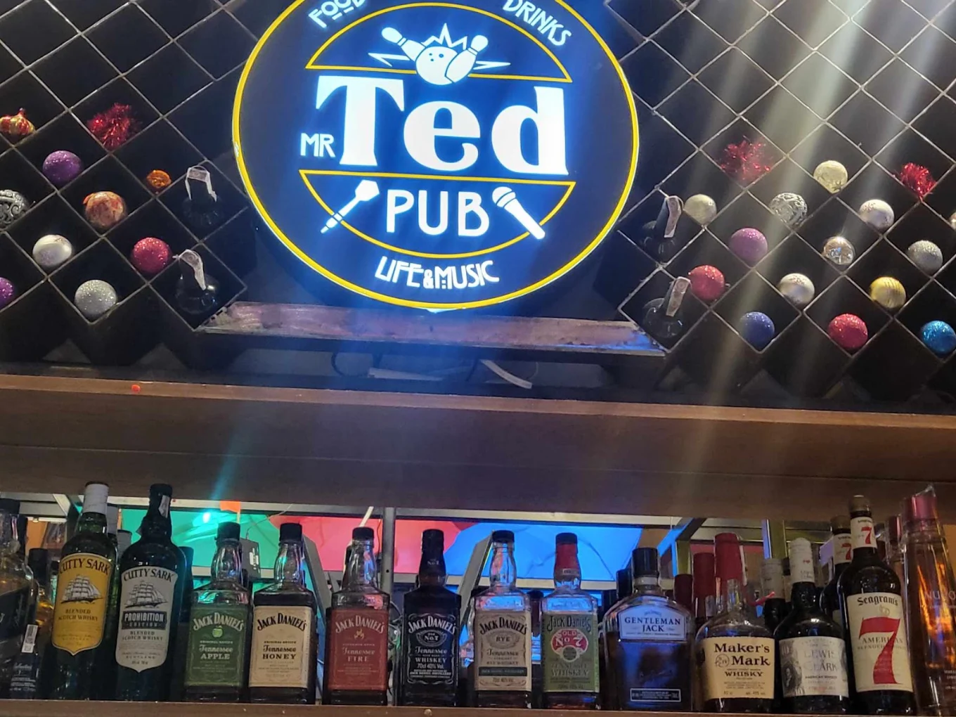 Logo Mr.Ted nad półką z alkoholami
